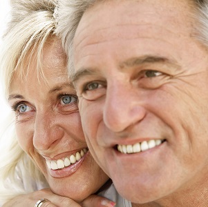 Older couple smiling because of quality New York restorative dentistry treatments