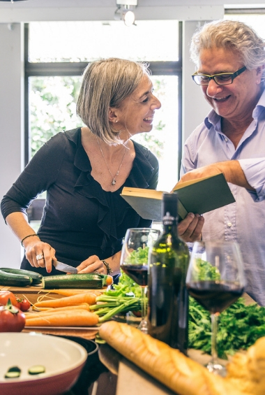 Older couple cooking healthy foods in the kitchen.