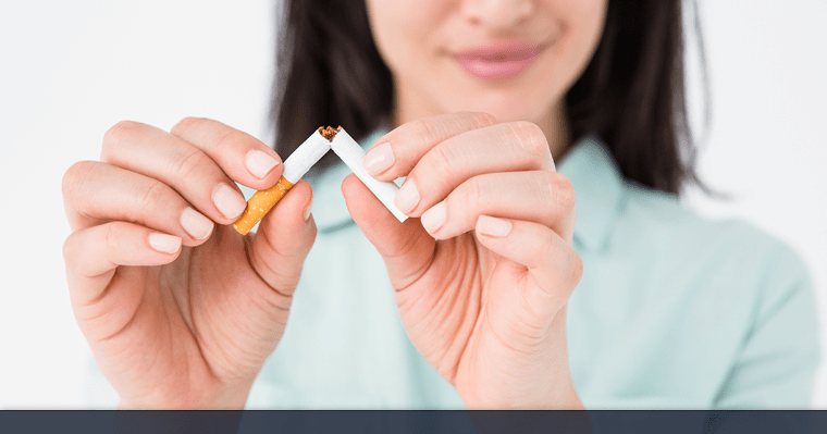 Woman breaking a cigarette in half.